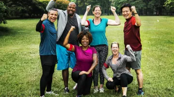 A group of friends in a park posing for a photo, smiling and having a good time